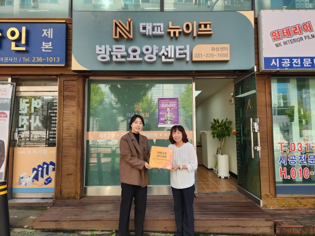 ▲ 치매극복선도단체로 신규 지정된 대교뉴이프 방문요양센터 화성센터에 화성시동부보건소 관계자가 현판을 전달하고 있다ⓒ화성시동부보건소 제공