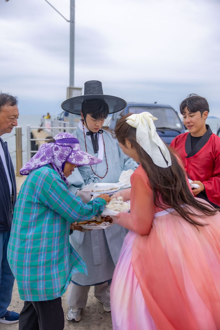 ▲ 인천시 옹진군 자월도에서 여행 참가자들이 노인들에게 직접 만든 송편과 간식을 나눠주고 있다. ⓒ인천항만공사 제공