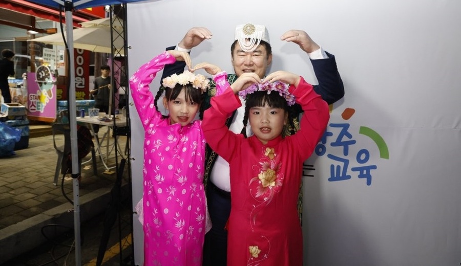 ▲ 이정선 광주광역시교육감이 지난 18일 광산구 월곡동 목련로 일원에서 광주 광산구 주최로 열린 ‘광산세계야시장’의 광주광역시서부교육지원청 운영부스인 ‘글로벌 야(夜)체(야시장 체험) 한마당’ 부스에서 전통의상을 입은 학생들과 하트포즈를 하며 기념사진을 촬영하고 있다.ⓒ광주시교육청 제공