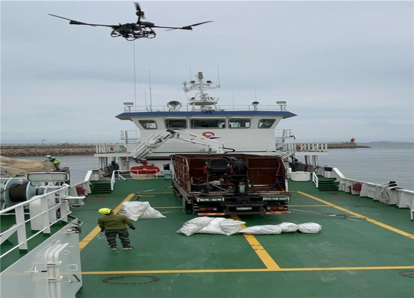 ▲ 인천 앞바다 섬지역 해안쓰레기를 드론이 운반선으로 옮기고 있다. ⓒ인천시 제공