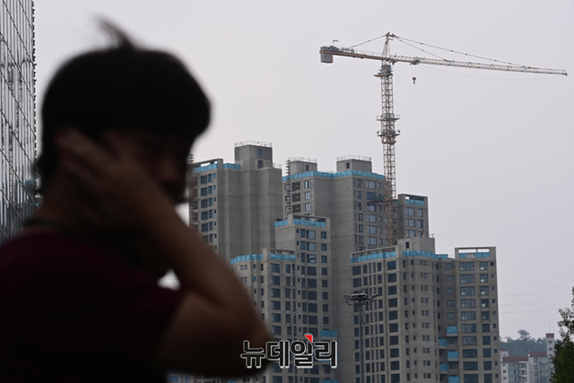 ▲ 서울 도심의 재개발 현장을 찾은 한 시민이 타워크레인을 바라보고 있다. ⓒ뉴데일리DB