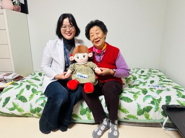 ▲ 화성시동탄보건소 관계자와 독거 어르신이 AI 돌봄로봇 ‘효돌이’를 들고 환하게 웃고 있다(자료사진)ⓒ화성시 제공