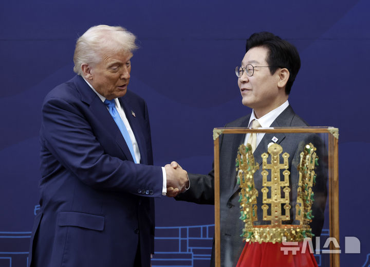 ▲ 이재명 대통령이 29일 경북 경주박물관에서 도널드 트럼프 미국 대통령에게 '금관 모형'을 선물하고 악수하고 있다. /경주=뉴시스