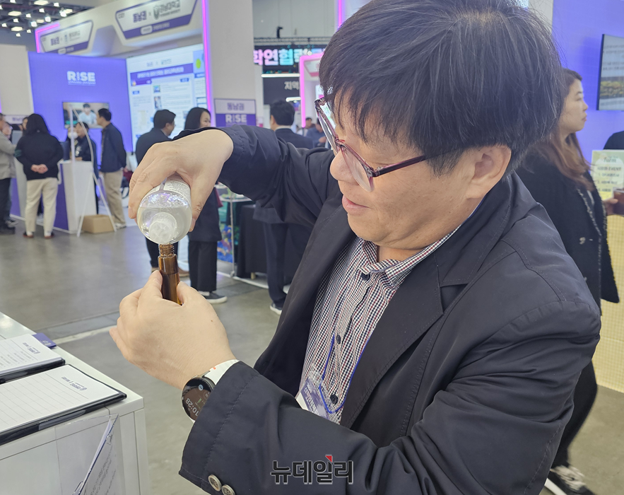 ▲ 반주현 충북RISE센터장이 30일 대구EXCO 극동대학교 부스에서 제품을 작은 병에 담는 시연을 하고 있다.ⓒ이길표 기자