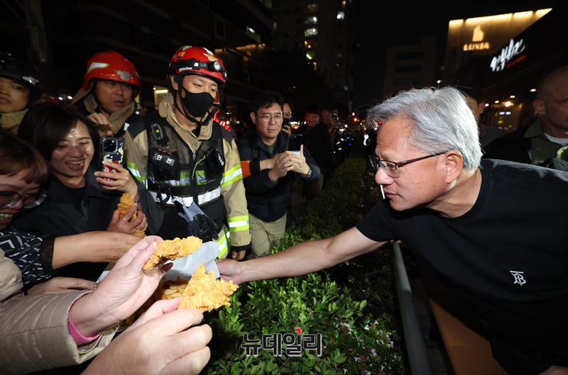 ▲ 젠슨 황 엔비디아 CEO가 30일 오후 이재용 삼성전자 회장, 정의선 현대자동차그룹 회장과 서울 강남구 깐부치킨 매장에서 치킨 회동 중 밖으로 나와 시민들에게 치킨 등을 나눠주고 있다.ⓒ정상윤 기자