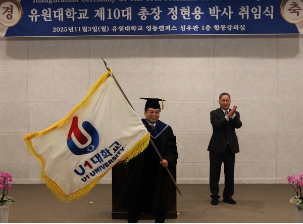 ▲ 유원대학교 제10대 정현용 총장이 지난 3일 취임식을 열고 새로운 도약을 선언했다. 정 총장은 채훈관 이사장으로부터 대학기를 넘겨 받은 뒤 힘차게 흔들고 있다.ⓒ유원대