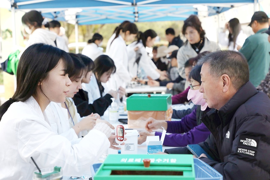 ▲ 영남이공대 간호학과 학생이 행사에 참여한 지역 주민의 혈당을 체크하고 설명하고 있다.ⓒ영남이공대