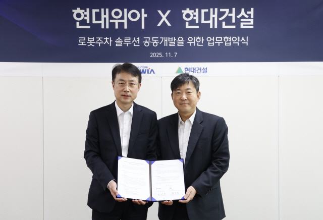 ▲ 김재영 현대건설 기술연구원 원장(오른쪽)과 백익진 현대위아 모빌리티솔루션사업부 상무가 기념촬영을 하고 있다. ⓒ현대건설
