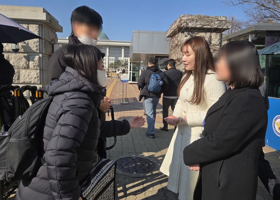 ▲ 19일 서울 여의도 국회 의사당 정문에서 김예지 국민의힘 의원이 지연성 PTSD 인정 촉구 시위 중인 연평해전 전사자 고(故) 한상국 상사의 배우자 김한나 씨를 만나 이야기를 듣고 있다. ⓒ김상진 기자