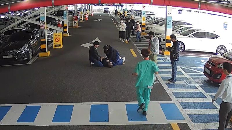 ▲ 병원 진료를 받기 위해 래원하던 70대가 주차장에서 심정지로 쓰러지자 점심 식사를 마치고 돌아오던 병원 직원들이 발견, 긴급 구조에 나서고 있다. ⓒ단국대병원
