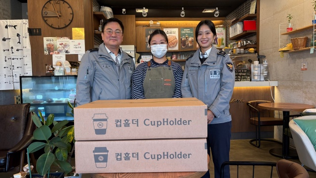 ▲ 5대 반칙운전과 픽시자전거 사고 예방 등의 메시지가 담긴 컵홀더를 카페에 전달하는 화성서부서 관계자들ⓒ화성서부경찰서 제공