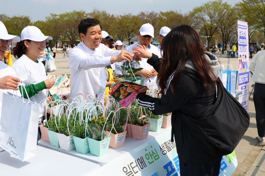 ▲ 박종길 근로복지공단 이사장(가운데)과 임직원들이 지닌해 4월 5일 식목일을 맞아 서울 여의도 한강공원에서 시민들을 대상으로 미니 화분과 씨앗키트를 나눠주는 행사를 갖고 있다. ⓒ근로복지공단