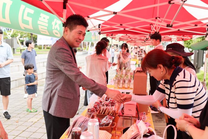 ▲ 김정헌(왼쪽) 인천 중구청장이 영종국제도시 ‘별빛광장 플리마켓’을 찾아 주민과 악수를 나누고 있다. ⓒ중구 제공