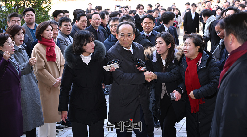 ▲ 계엄 해제 표결 방해 혐의을 받는 추경호 전 국민의힘 원내대표가 2일 오후 서울 서초구 서울중앙지법에서 열린 영장실질심사(구속 전 피의자 심문)에 출석하며 국민의힘 의원들의 응원을 받고 있다. ⓒ서성진 기자