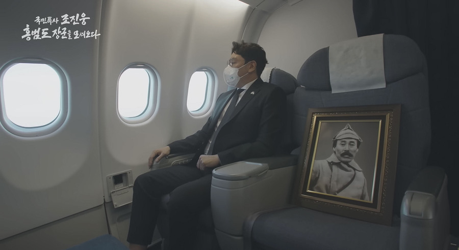 ▲ 문재인 정부 시절인 2021년 8월, 배우 조진웅이 국민 특사로 카자흐스탄에서 홍범도 장군의 유해를 모셔왔다. 한국행 비행기 안에 조 특사 옆자리에 홍범도 장군 영정이 놓여있다. /KBS 캡처
