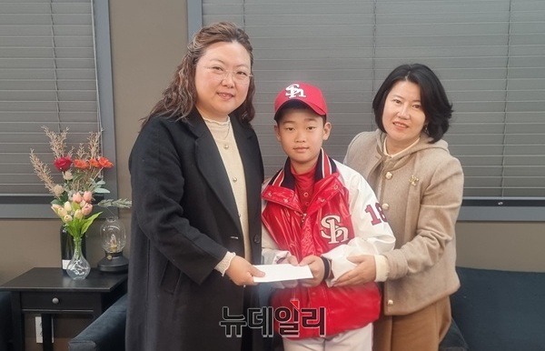 ▲ 대전 신흥초등학교 이성민 군(왼쪽 2번째)이 12만원을 기부하고 김미정 사무국장과 기념사진을 촬영하고 있다.ⓒ김경태 기자