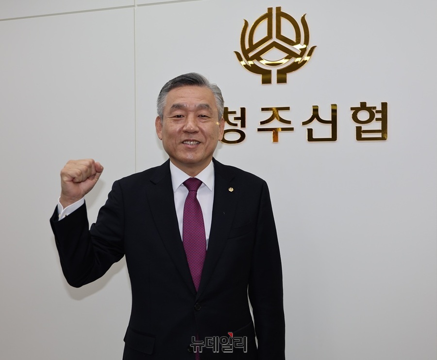 ▲ 남청주신협 송재용 이사장이 신협로그를 배경으로 파이팅을 하고 있다.ⓒ김정원 기자