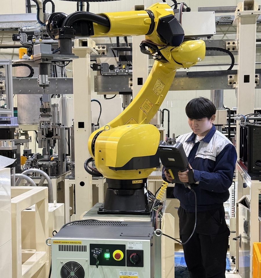 ▲ ‘선취업·후진학’으로 4년 만에 석사과정을 밟고 있는 박예성 씨가 평화이엔지 현장에서 자동화공정 로봇을 시운전하고 있다.ⓒ영진사이버대