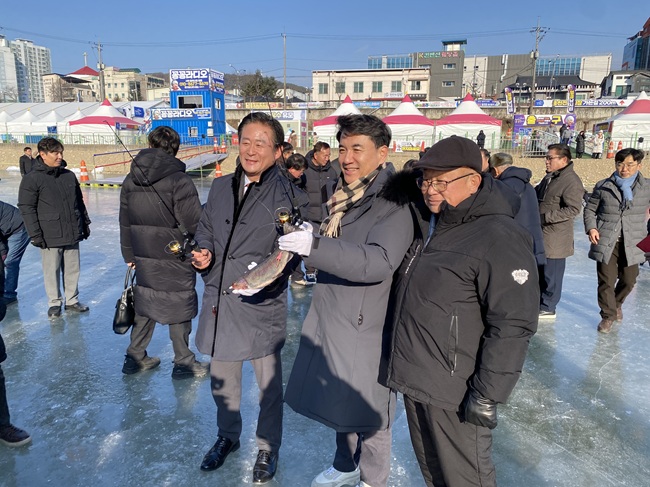 ▲ 송어를 들고 웃고 있는 김진태 도지사와 신영재 홍천군수 모습. ⓒ뉴데일리