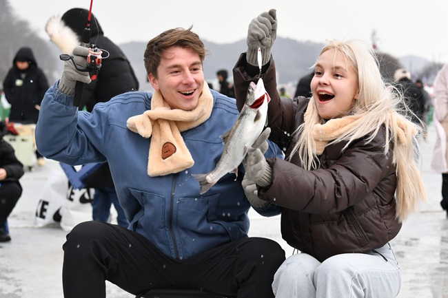 ▲ 산천어를 잡아 즐겁게 웃고 있는 외국인 관광객들 모습. ⓒ화천군