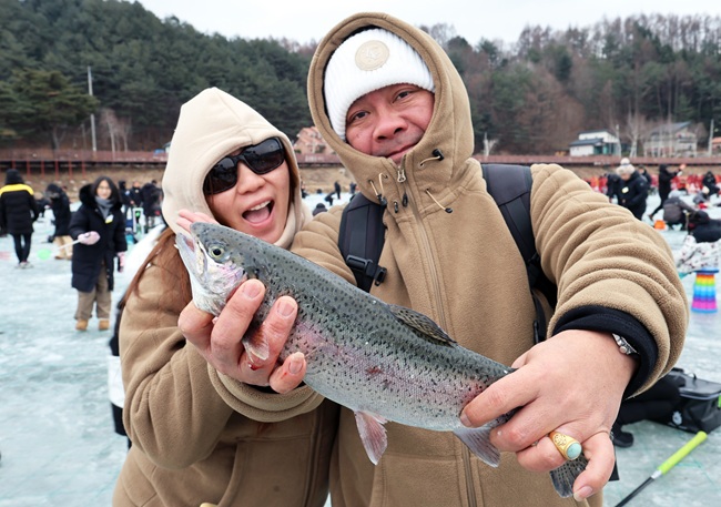 ▲ 14일 강추위 속에 강원도 평창군 진부면 오대천 일원에 열린 평창송어축제를 찾은 외국인 방문객이 얼음낚시로 잡은 송어를 들어 보이고 있다. '겨울이 더 즐거운 송어 나라, 평창'이라는 주제로 열린 올해 축제는 송어낚시를 넘어 전시·문화·휴식 콘텐츠를 강화한 겨울 종합 관광축제로 내달 9일까지 방문객을 맞는다. ⓒ평창군