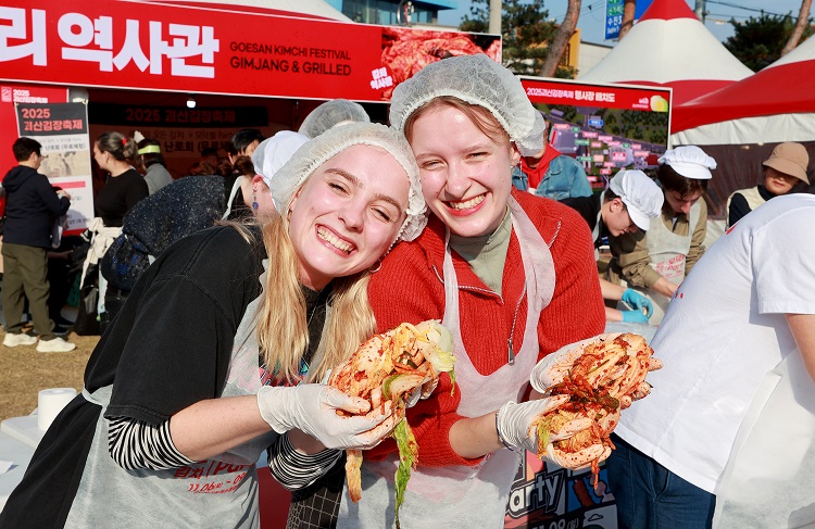 ▲ 괴산 김장축제에 참가한 외국인 관광객이 김장체험을 통해 직접 담근 김치를 들고 환하게 웃고 있다.