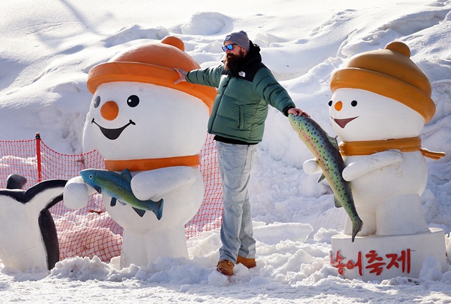 ▲ 주말을 맞아 강원도 평창군 진부면 오대천 일원에 열린 평창송어축제를 찾은 외국인 방문객이 눈동이 조각을 배경으로 기념사진을 촬영하고 있다. '겨울이 더 즐거운 송어 나라, 평창'이라는 주제로 열린 올해 축제는 내달 9일까지 방문객을 맞는다. ⓒ평창군