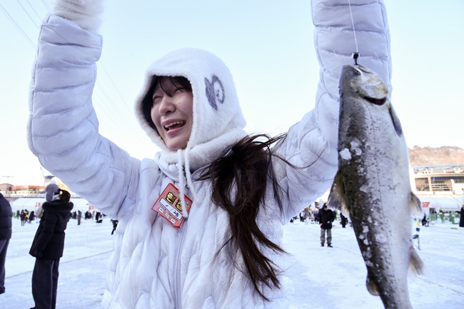 ▲ 25일, 주말을 맞아 이른 아침부터 화천산천어축제장을 찾은 관광객들이 산천어 얼음낚시터에서 산천어를 낚아 올리며 즐거워하고 있다. ⓒ화천군