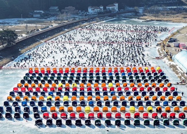 ▲ 25일 휴일을 맞아 강추위에도 불구하고 강원도 평창군 진부면 오대천 일원에 열린 평창송어축제에 많은 방문객이 몰려 송어 얼음낚시를 즐기고 있다. 올해 축제는 송어낚시를 넘어 전시·문화·휴식 콘텐츠를 강화한 겨울 종합 관광축제로 내달 9일까지 방문객을 맞는다. ⓒ평창관광문화재단