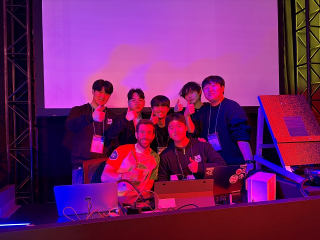 ▲ 경기대 학생들이 주축이 된 연합팀이 Pwn2Own Automotive 2026에서 시연 후 기념촬영을 하고 있다. ⓒ경기대 제공