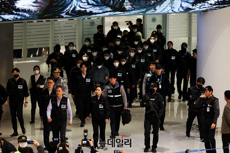 ▲ 캄보디아를 거점으로 범죄를 저지른 한국 국적 피의자 73명이 23일 오전 인천국제공항 제2여객터미널을 통해 강제 송환되고 있다. ⓒ서성진 기자