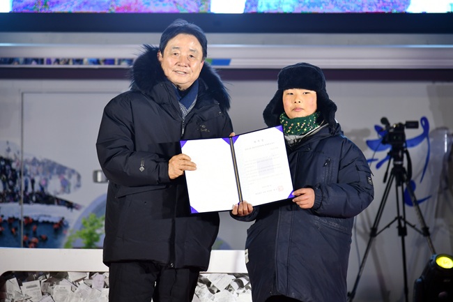 ▲ 2026 화천산천어축제 폐막식이 1일 축제장에서 열렸다. 최문순 화천군수가 이은성 군에게 명예 산천어축제 홍보대사 위촉장을 전달하고 있다. ⓒ화천군