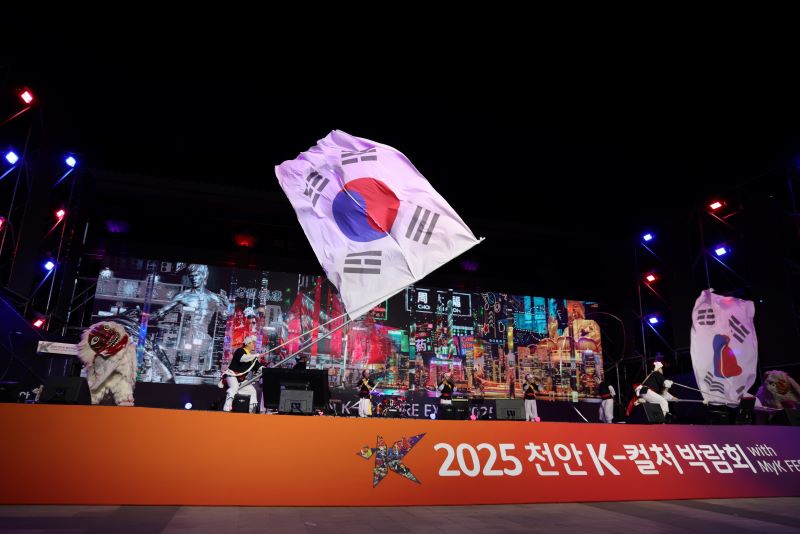 ▲ ‘2025 천안 K-컬처박람회’ 개막식 중 대형 태극기가 무대위에서 휘날리는 모습.ⓒ천안시