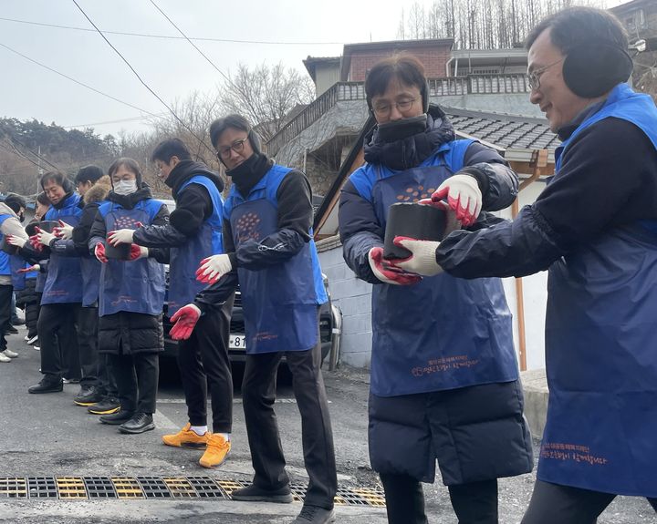 ▲ 신한투자증권 이선훈 대표, 정용욱 신한프리미어총괄사장, 정근수 CIB총괄사장 등 임직원들이 개미마을에서 연탄봉사활동을 진행했다. ⓒ신한투자증권