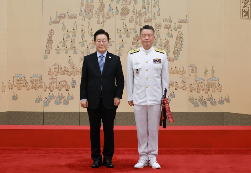 ▲ 이재명 대통령이 지난해 9월 2일 서울 용산 대통령실 청사에서 열린 대장 진급·보직 신고 및 삼정검 수치 수여식에서 강동길 해군참모총장의 삼정검에 수치를 달아준 뒤 기념 촬영하는 모습. ⓒ뉴시스