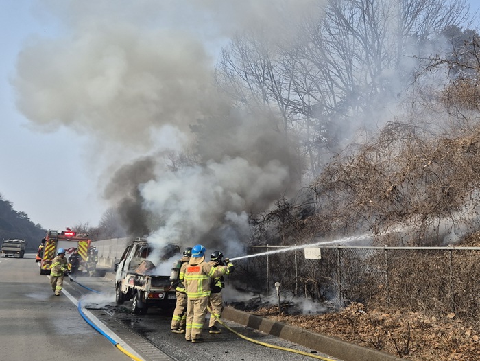 ▲ 13일 오전 10시 42분께 충남 공주시 월미동 대전당진고속도로 당진방향 67.2㎞ 지점에서 1톤 화물차에 불이 났 소방대원들이 진화작업을 하고 있다.ⓒ공주소방서