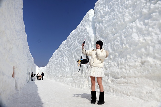 ▲ 13일 평창군 대관령면 횡계리 송천 일대 축제장에서 개막한 전국 최고의 눈과 얼음축제인 제34회 평창 대관령눈꽃축제를 찾은 방문객들이 눈빙벽을 배경으로 기념사진을 촬영하고 있다. ⓒ평창관광문화재단