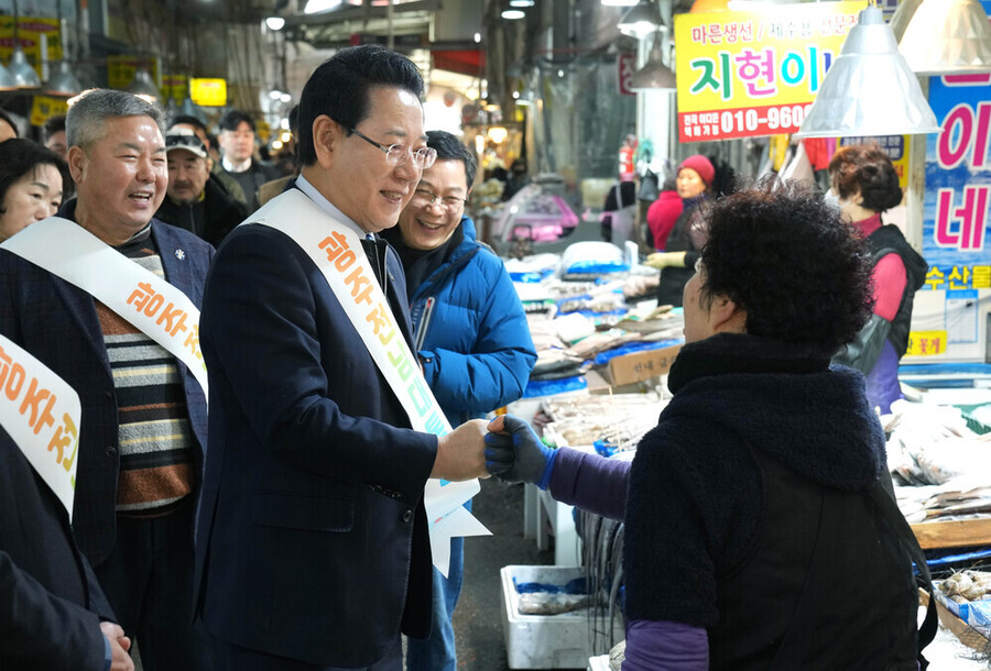 ▲ 김영록 전라남도지사가 설 명절을 앞둔 15일 지역 전통시장인 광주 양동시장을 방문해 전남·광주 행정통합의 취지와 추진 방향을 설명하고 물품을 구매하며 상인들을 격려하고 있다.ⓒ전라남도 제공