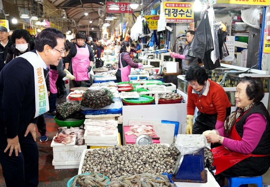 ▲ 김영록 전라남도지사가 설 명절을 앞둔 15일 지역 전통시장인 광주 양동시장을 방문해 전남·광주 행정통합의 취지와 추진 방향을 설명하고 물품을 구매하며 상인들을 격려하고 있다.ⓒ전라남도 제공