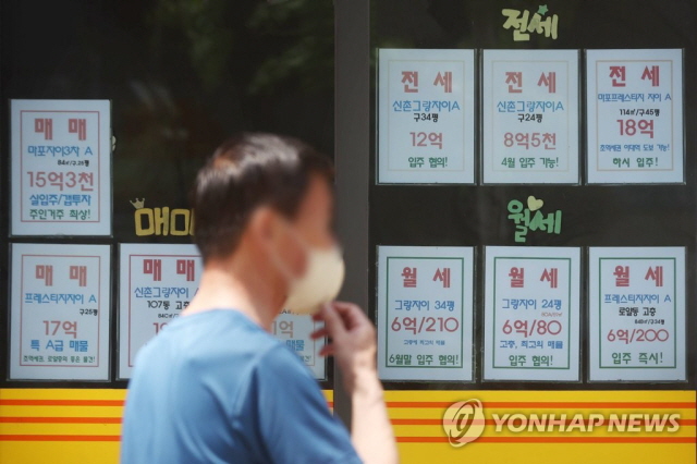 ▲ 한 시민이 공인중개소 안내문을 지나치고 있다. ⓒ연합뉴스