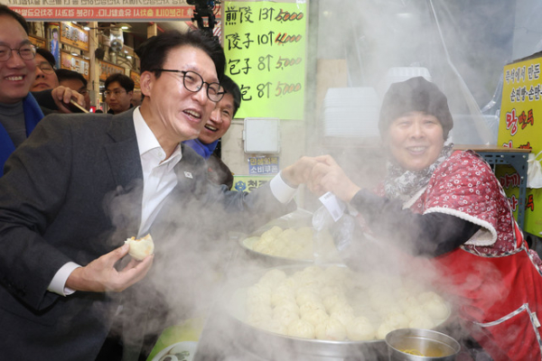 ▲ 김민석 국무총리(왼쪽)가 12일 설을 앞두고 물가를 점검하기 위해 충북 청주 육거리종합시장을 찾아 만두를 사먹으며 상인과 악수하고 있다. ⓒ연합뉴스