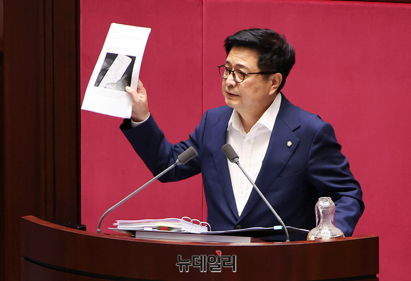 ▲ 김장겸 국민의힘 의원이 2025년 8월 5일 오후 국회에서 열린 본회의에서 방송문화진흥회법 일부개정법률안이 상정되자 무제한 토론(필리버스터)을 하며 보좌진 명의의 차명 계좌로 주식 거래를 했다는 의혹을 받고 있는 이춘석 더불어민주당 의원 관련 기사를 들어보이고 있다. ⓒ서성진 기자