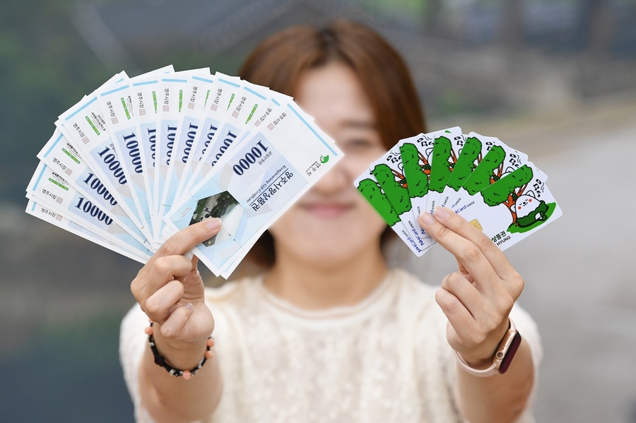 ▲ 영주사랑상품권은 3월 1일부터 영주사랑상품권 할인율을 12%로 상향한다(영주사랑상품권.체크카드를 들고 있는 시민 모습).ⓒ영주시