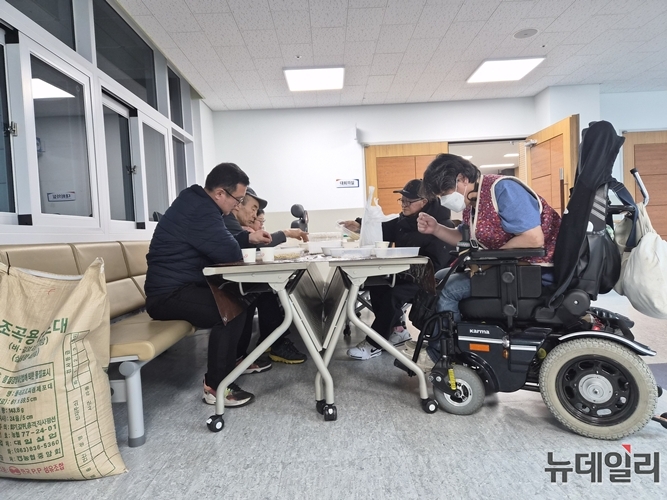 ▲ 4층 로비에서 몸이 불편한 장애인 봉사자들이 삼삼오오 모여 콩 고르기 작업을 하고 있다. ⓒ표윤지 기자