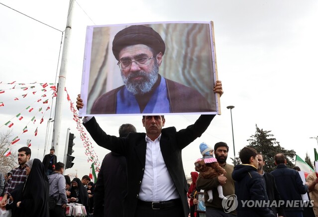 ▲ 하메네이의 차남인 모즈타바의 사진을 들고 있는 이란 시민. 출처=EPAⓒ연합뉴스