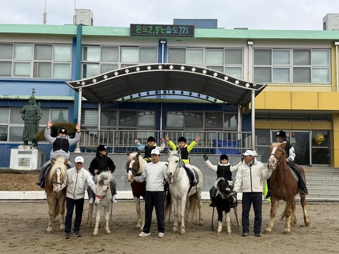 ▲ 인천 강화군 양도면 조산초교에서 입학생 2명이 말을 타고 교문에 들어서는 입학식을 하고 있다. ⓒ 강화자연체험농장 제공