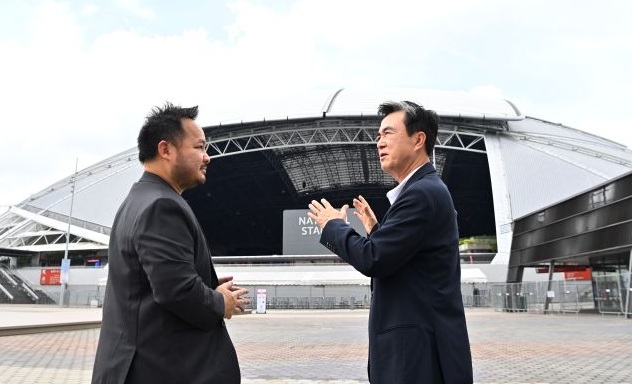 ▲ 김태흠 충남도지사(오른쪽)가 지난 5일 싱가포르 국립경기장 앞에서 싱가포르 스포츠 허브 관계자에게 돔구장에 대해 묻고 있다.ⓒ충남도