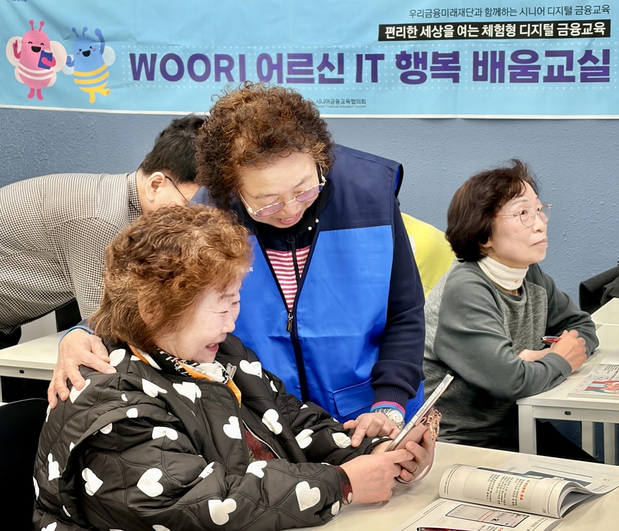 ▲ 우리 어르신 IT 행복 배움교실’ 에서 전년도 우수 수강생 강옥연씨가 보조강사로 활동하며 다른 수강생들을 돕고 있다. ⓒ우리금융그룹.