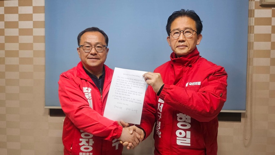 ▲ 홍성주·김형일 예비후보(왼쪽부터)가 단일화 합의서를 들고 악수하는 장면.ⓒ김형일 예비후보 페이스북 캡쳐