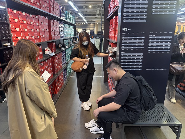▲ 나이키 매장에서 제품을 신어보는 외국인 관광객 ⓒ신세계사이먼